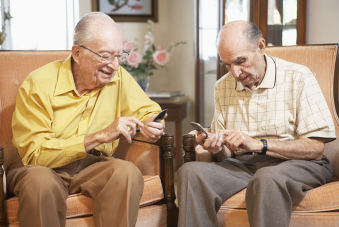 Deux messieurs âgées consultent leurs téléphones portables