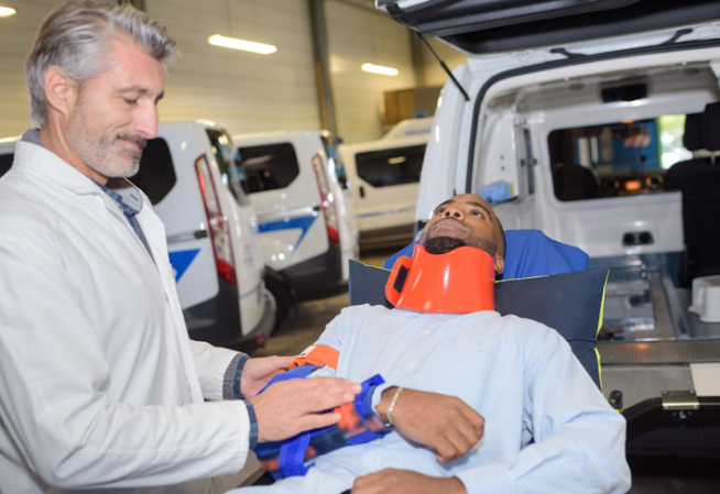 Une personne blessée sur un brancard, accompagné d'un professionnel de santé 