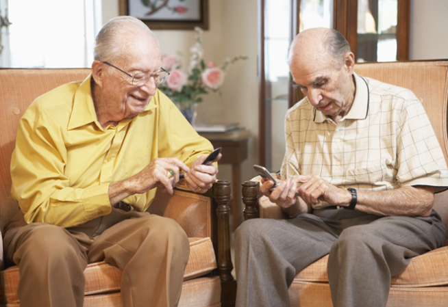 Deux messieurs âgées consultent leurs téléphones portables