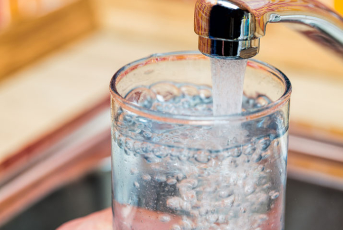 Verre d'eau rempli depuis un robinet